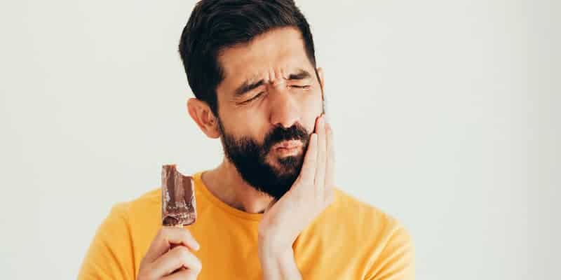 Homem com sensibilidade nos dentes clareamento dental